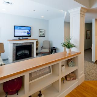 A modern living room featuring a fireplace, wall-mounted TV, and built-in shelving.