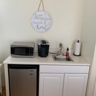 A compact kitchenette setup with essential appliances including a microwave, mini fridge, and coffee maker.