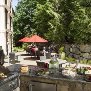 A cozy backyard with an outdoor kitchen and seating area, perfect for a summer barbecue.