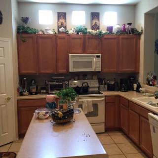 A cozy kitchen with wooden cabinets, a countertop, and various appliances.