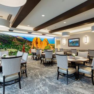 A modern dining area with elegant seating and a colorful mural on the wall.