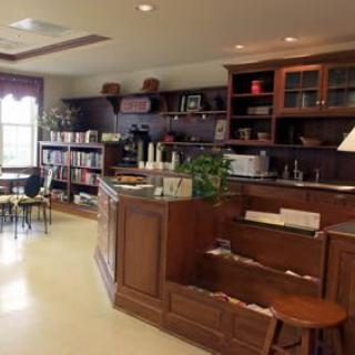 A cozy cafe interior with wooden furniture and shelves.