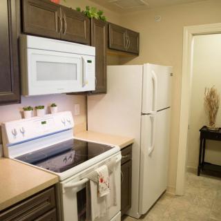 A modern kitchen with essential appliances including a stove, microwave, and refrigerator.