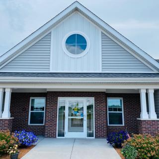 Front view of a building with brick exterior and a triangular roof.