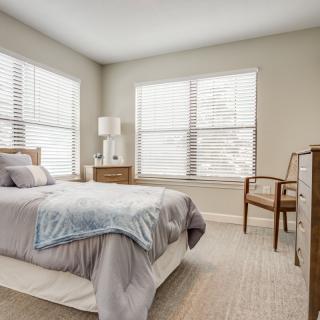 A modern, minimalist bedroom with a cozy bed and stylish furniture.