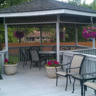 An inviting gazebo with outdoor seating and vibrant flowers in pots and hanging baskets.