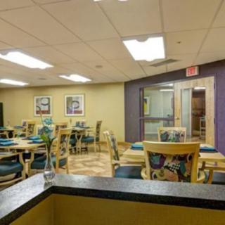 An empty dining area with several tables and chairs, featuring modern decor.