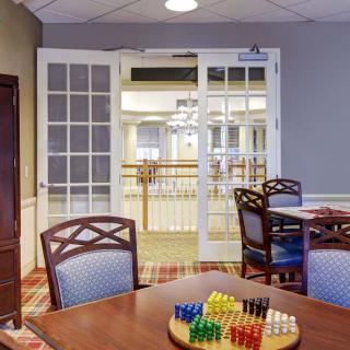 A communal game room with tables, chairs, and a board game set up.