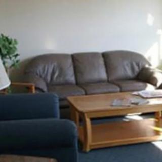 A cozy living room with a brown leather sofa and a wooden coffee table.