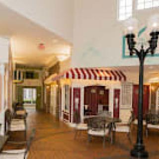 A cozy indoor space featuring a small storefront with a striped canopy, seating areas, and a decorative street lamp.