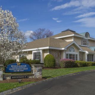A suburban residential building with a landscaped front yard and driveway.