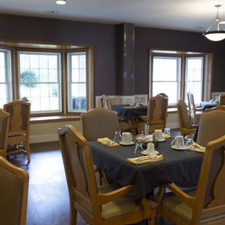 An empty dining room with tables set for meals.