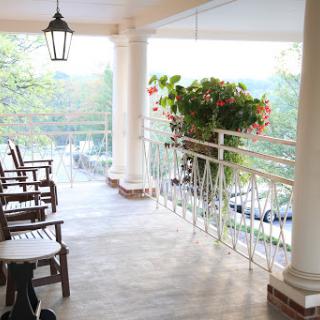 A serene balcony setting with wooden chairs and vibrant plants, perfect for enjoying the views.