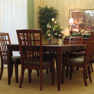 A stylish dining room featuring a wooden table and chairs, adorned with floral decorations.