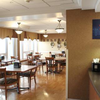 A spacious and well-lit dining area with tables and chairs, perfect for enjoying meals.
