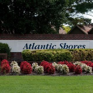 A beautifully landscaped entrance sign for Atlantic Shores, surrounded by vibrant flowers.