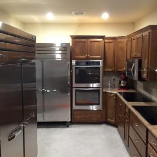 Modern kitchen with wooden cabinets, stainless steel appliances, and double ovens.