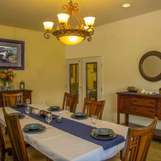 A well-decorated dining room with a large table set for dinner.