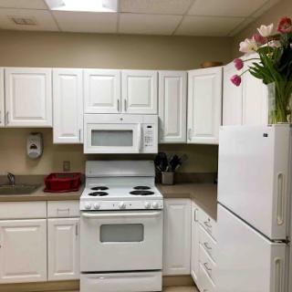 A clean and modern kitchen setup featuring white cabinetry and appliances.