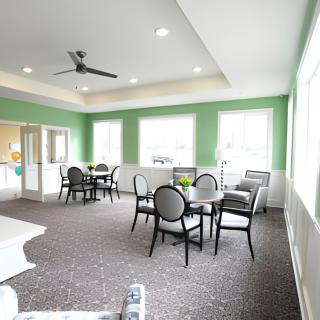 A bright and modern dining area with green walls, featuring multiple tables and chairs under natural lighting.