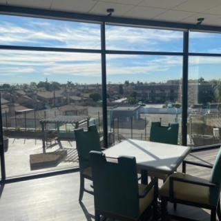 A scenic view through large windows in a modern indoor setting with a table and chairs.