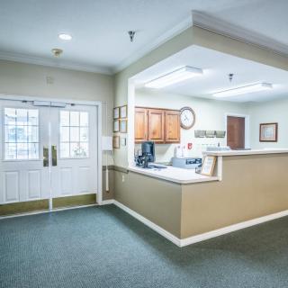 A well-lit reception area with a desk and double doors.