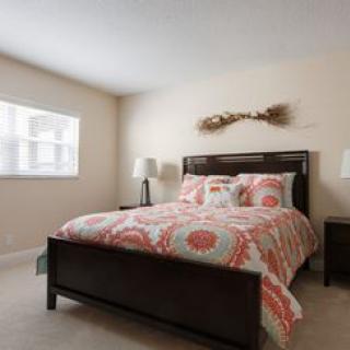 A cozy bedroom with a patterned bedspread and warm lighting.