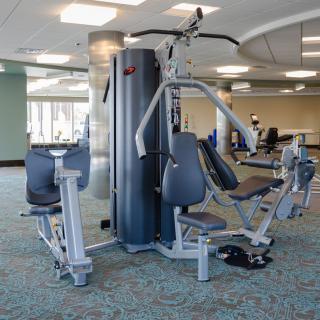 A gym setup featuring a multi-functional weight machine for strength training.