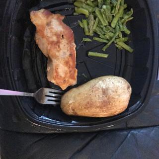 A delicious plate featuring grilled chicken, a baked potato, and steamed green beans.