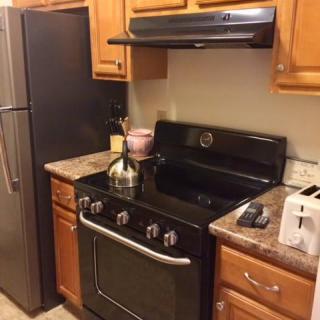 A cozy kitchen with modern appliances including a stove, oven, refrigerator, and toaster.