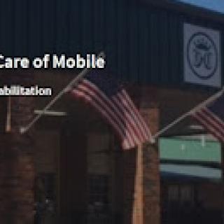 Exterior view of a rehabilitation center in Mobile, showcasing American flags.