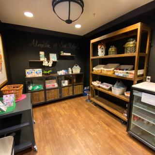 A cozy gift shop with wooden shelves displaying various products.