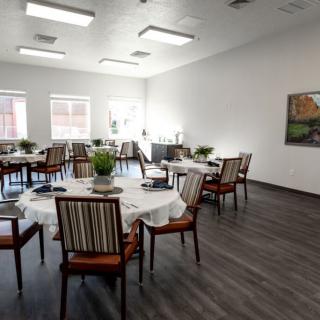A well-arranged dining room with multiple tables and chairs, featuring modern decor.