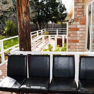 Black chairs arranged on a patio with a view of the yard.