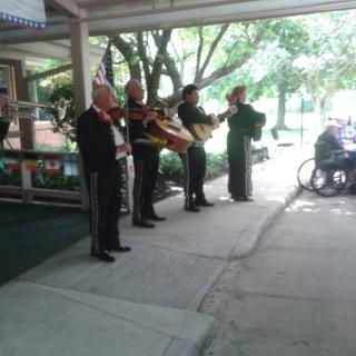 A mariachi band performing outdoors in traditional attire.