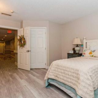 A cozy bedroom with a neatly made bed and a lamp on the nightstand.