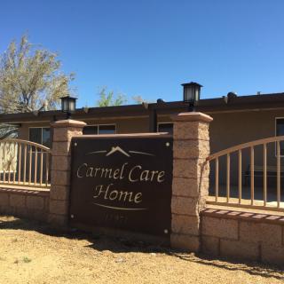 A sign for 'Eternal Care Home' in front of a single-story building on a sunny day.