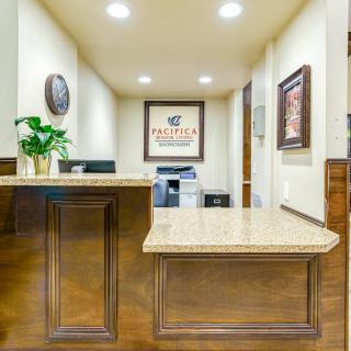 A well-lit reception area with a polished desk and decorative elements.