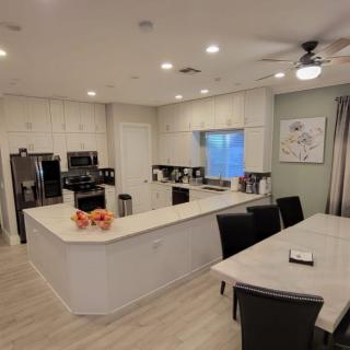 A modern open-concept kitchen and dining area with white cabinetry and an island counter.