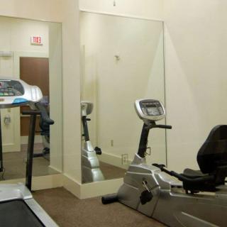 A small gym room with a treadmill and stationary bike.