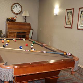 A game room featuring a billiards table with pool balls arranged for play.
