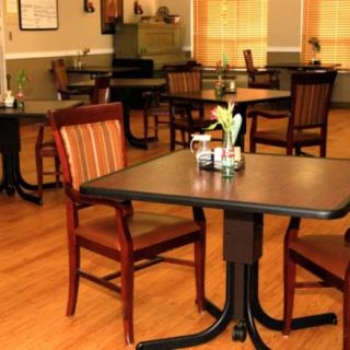 An empty restaurant dining area with neatly arranged tables and chairs.