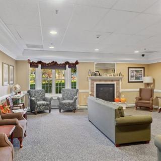 A cozy living room with comfortable seating, a fireplace, and large windows.