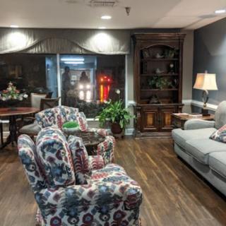 Cozy living room with patterned armchairs, a plush sofa, and elegant decor.