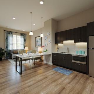 A modern open-plan kitchen and dining area with wood flooring and minimalist decor.