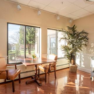 A bright and inviting office space featuring large windows and wooden furniture.
