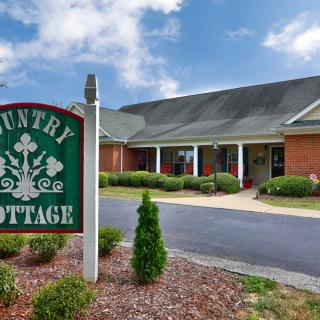 A country-style building with a driveway and a sign reading 'Country Cottage'.