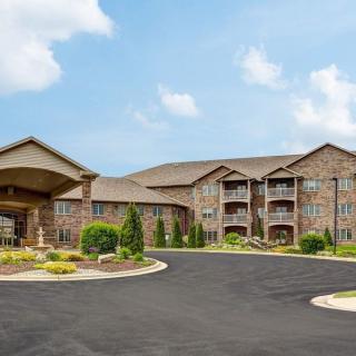 A large residential apartment complex with well-maintained landscaping and a spacious driveway.