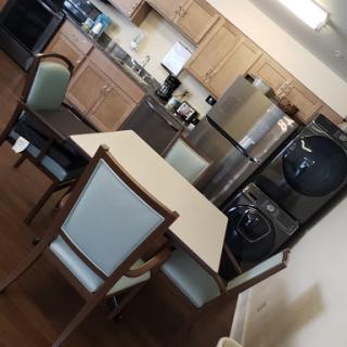 A cozy and functional kitchen dining area featuring modern appliances and a simple table set.