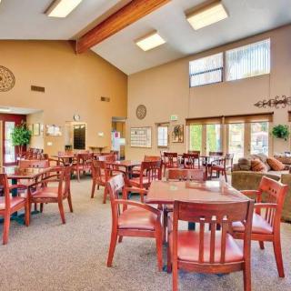 A spacious, well-lit community dining area with wooden tables and chairs.